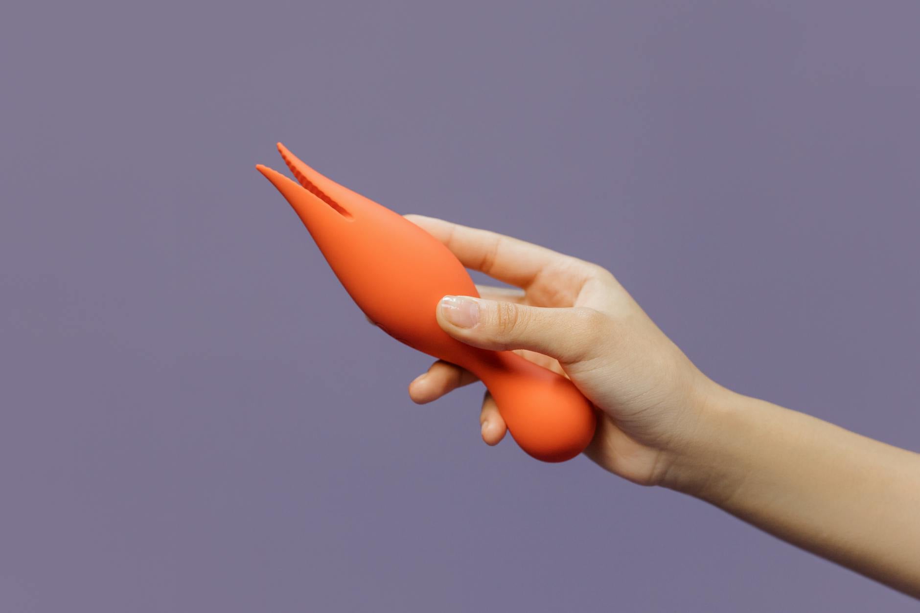 A hand holding a lemon-shaped vibrator, representing reclaimed personal pleasure and intimacy.