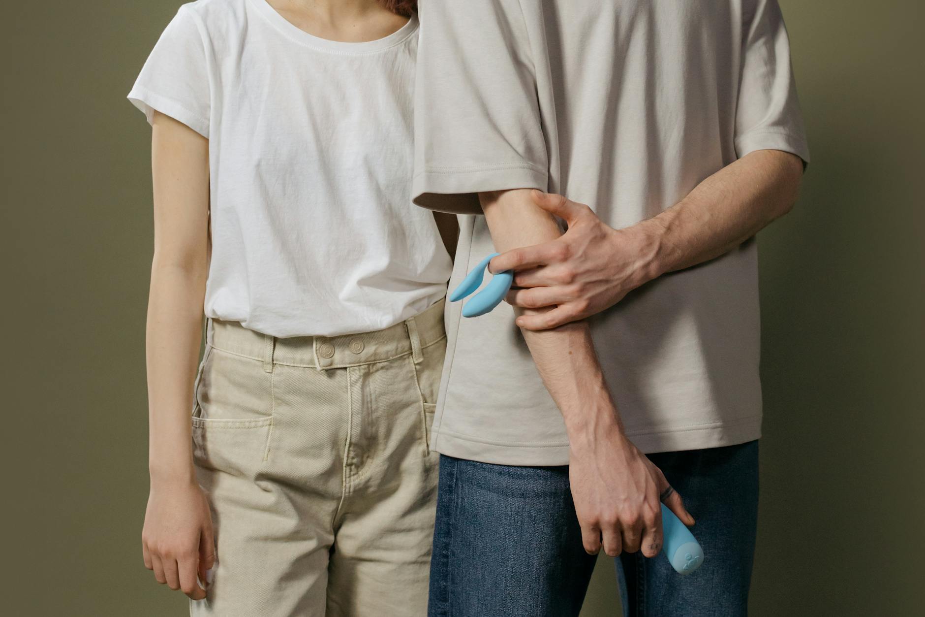 Woman holding blue and pink silicone vibrators, showing tools for reconnecting with bodily sensation.
